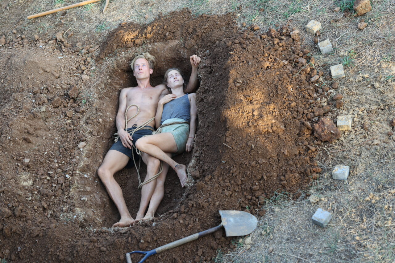 Two CPPM students lying in the ground during their six-hour durational work in Karyes